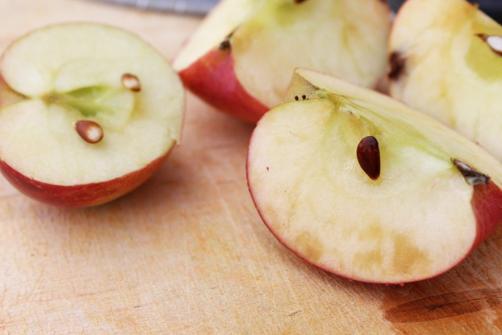 Two apples, cut open to show the color of the pips, to help determine ripeness.